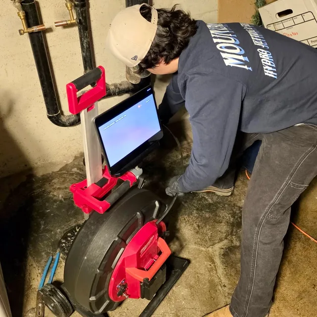Mountain West technician using a sewer camera and monitor to inspect a drain in Utah.