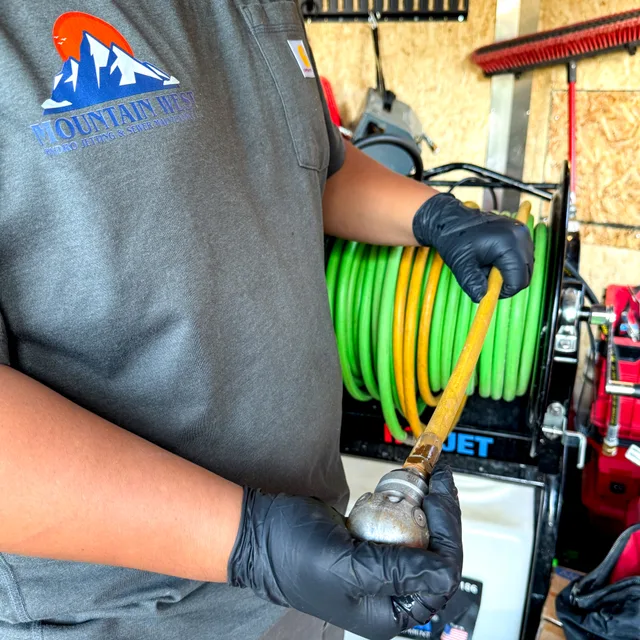 Mountain West technician connecting a hose beside the hydro jetting reel in Utah.