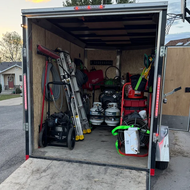 Tools, hose reels, and equipment stored inside the Mountain West service trailer in Utah.