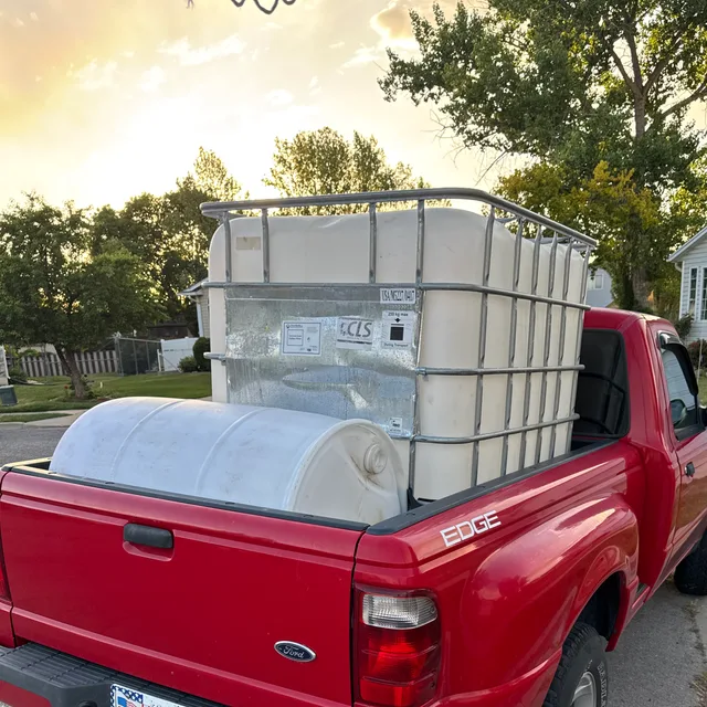 Water tanks loaded in the bed of a red service truck in Utah.
